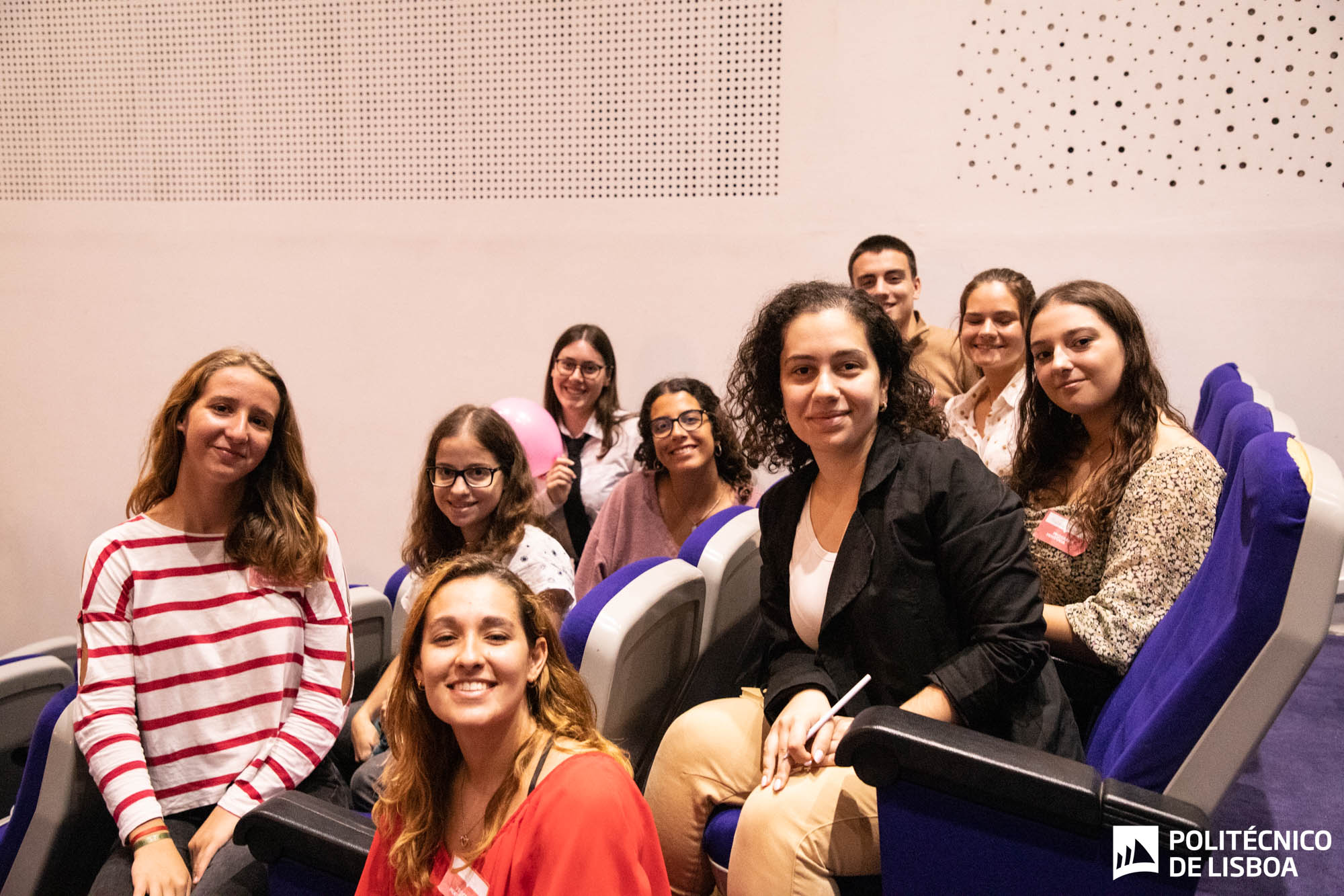 estudante sentados num auditório a sorrir