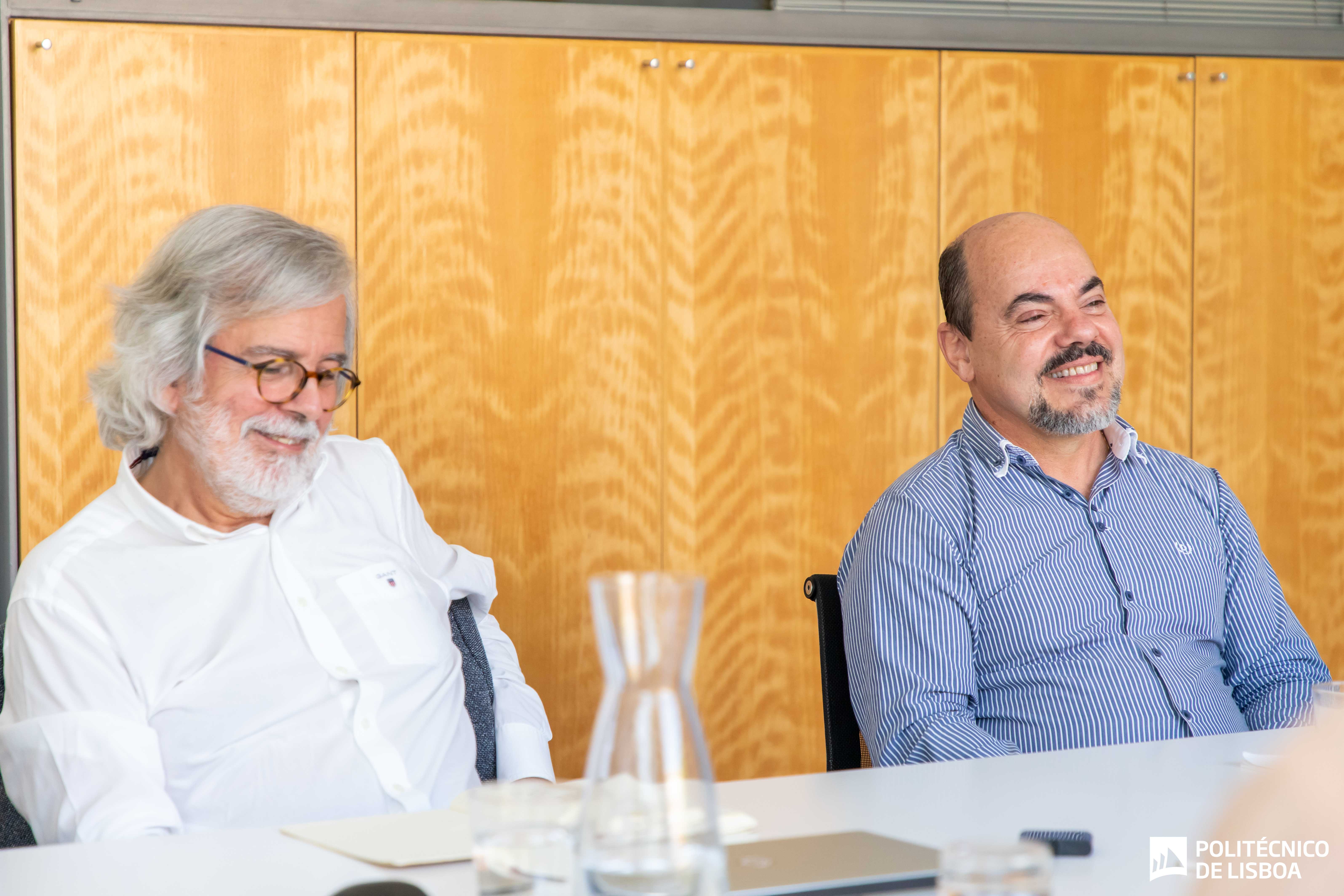 dois homens sentados a uma mesa de reuniões