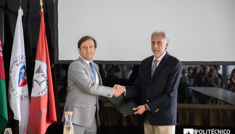 Foto com dois homens em pé a dar um aperto de mão