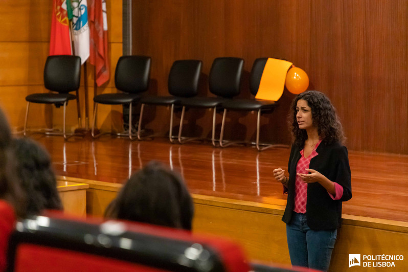 mulher a falar de pé para um auditório