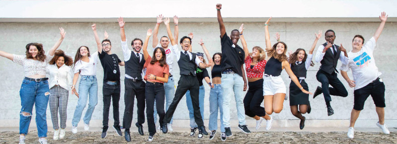 estudantes a saltar de braços no ar