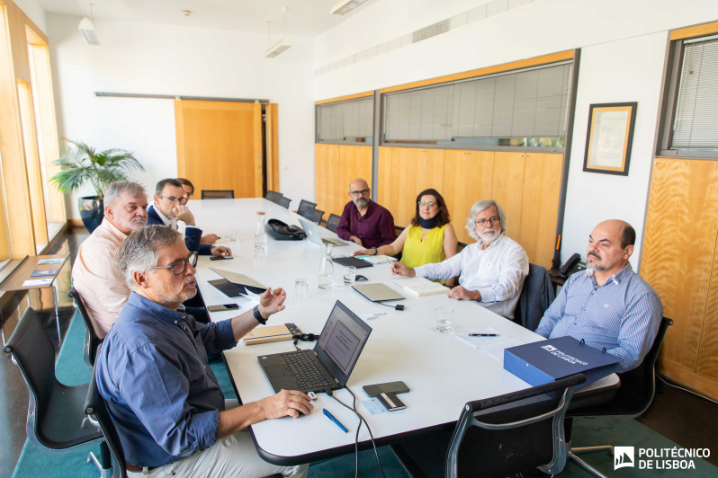 pessoas sentadas junto a uma mesa de reunião