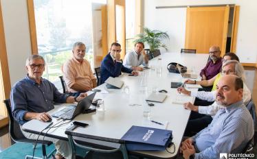 pessoas sentadas a uma mesa de reuniões numa sala 