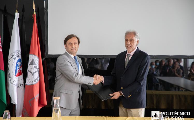 Foto com dois homens em pé a dar um aperto de mão