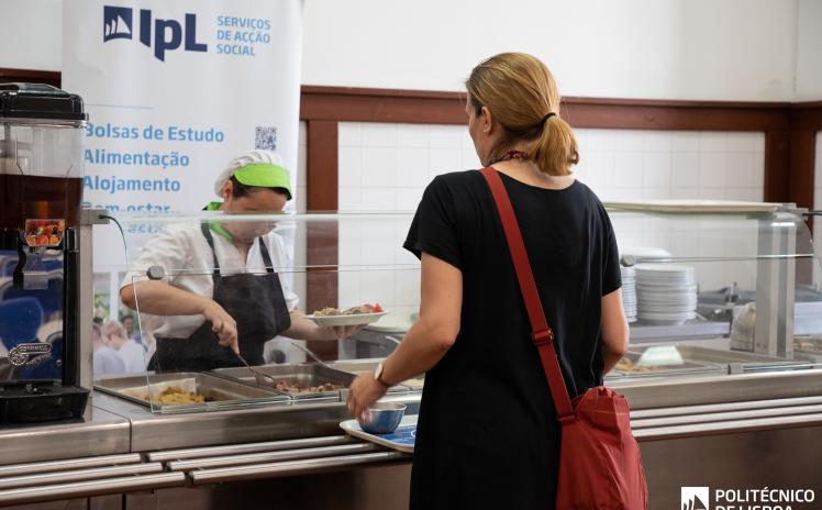 foto de uma cantina com a funcionária que serve e o utilizador com o tabuleiro